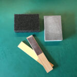 Æskens kanter slibes med sandpapir for at fjerne ujævnheder